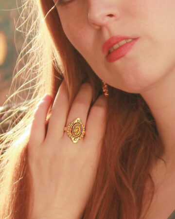 A-quiet-redhead-girl-softly-touching-her-long-mane-and-wearing-and-adjustable-gold-plated -vintage-ring