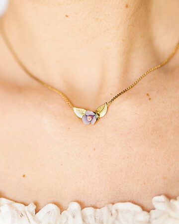 Lady-neckline-wearing-a-dainty-gold-plated-snake-chain-choker-necklace with-pastel-porcelain rose-and-tiny-gold-leaves.